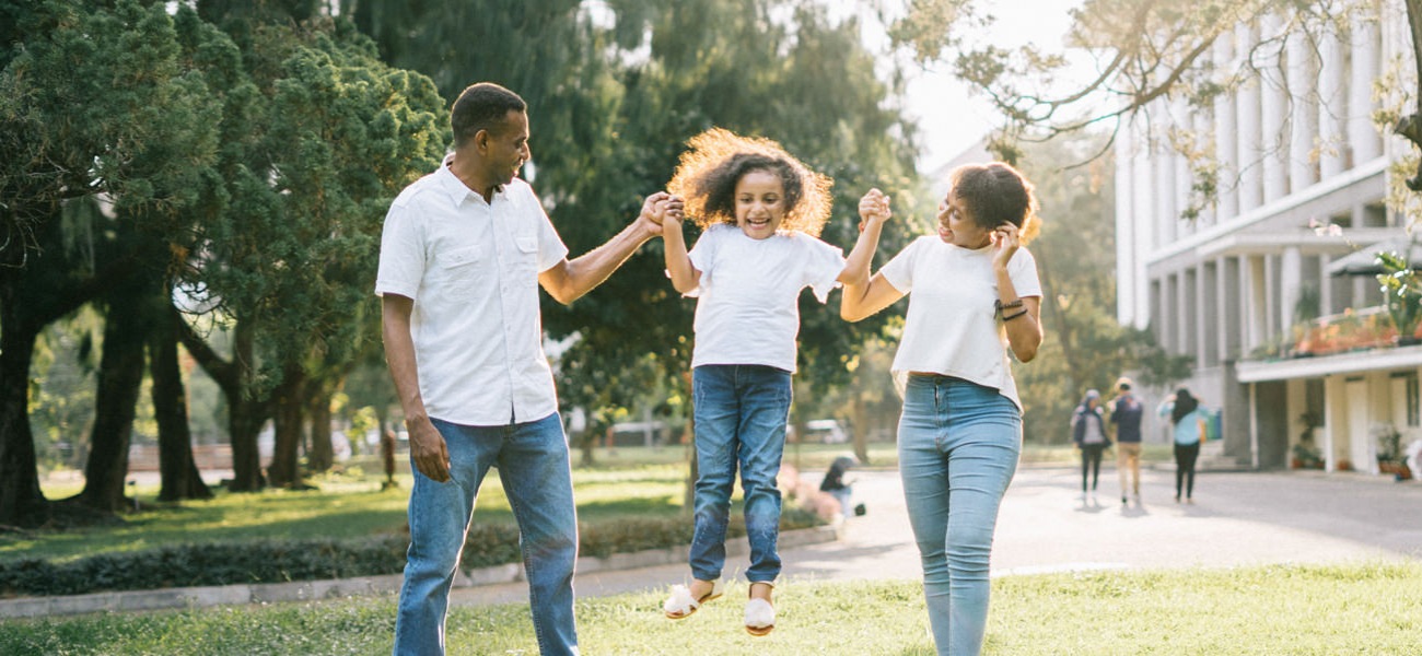 Father and Mother holding daughter up by arms